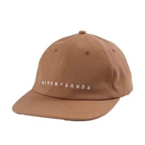 Brown dad hat with flat brim and white embroidered "RIVER + SANDS" logo.