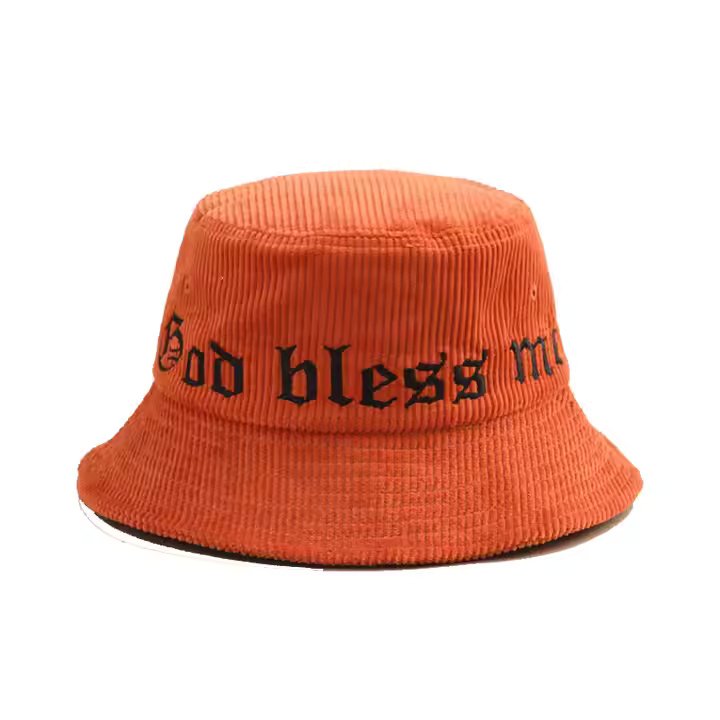 Orange corduroy XL bucket hat with black embroidered "God bless me" text.