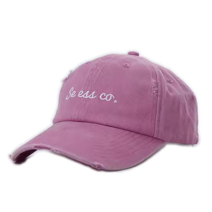Pink embroidered dad hat with white script logo and distressed detailing.